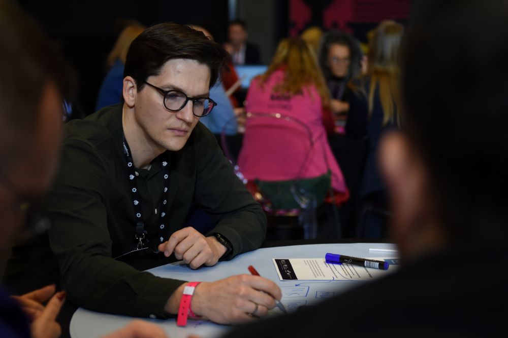 Uczestnik piszacy na plakacie