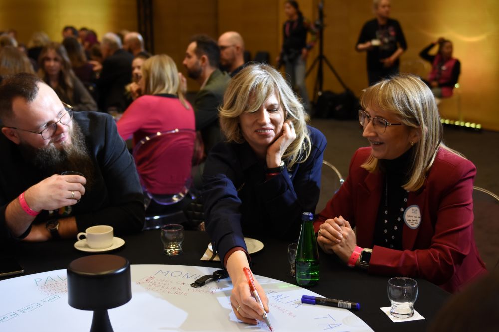 Uczestnicy I Kongresu POP Science, podczas pracy przy okrągłym stole (dwie kobiety i jeden mężczyzna).